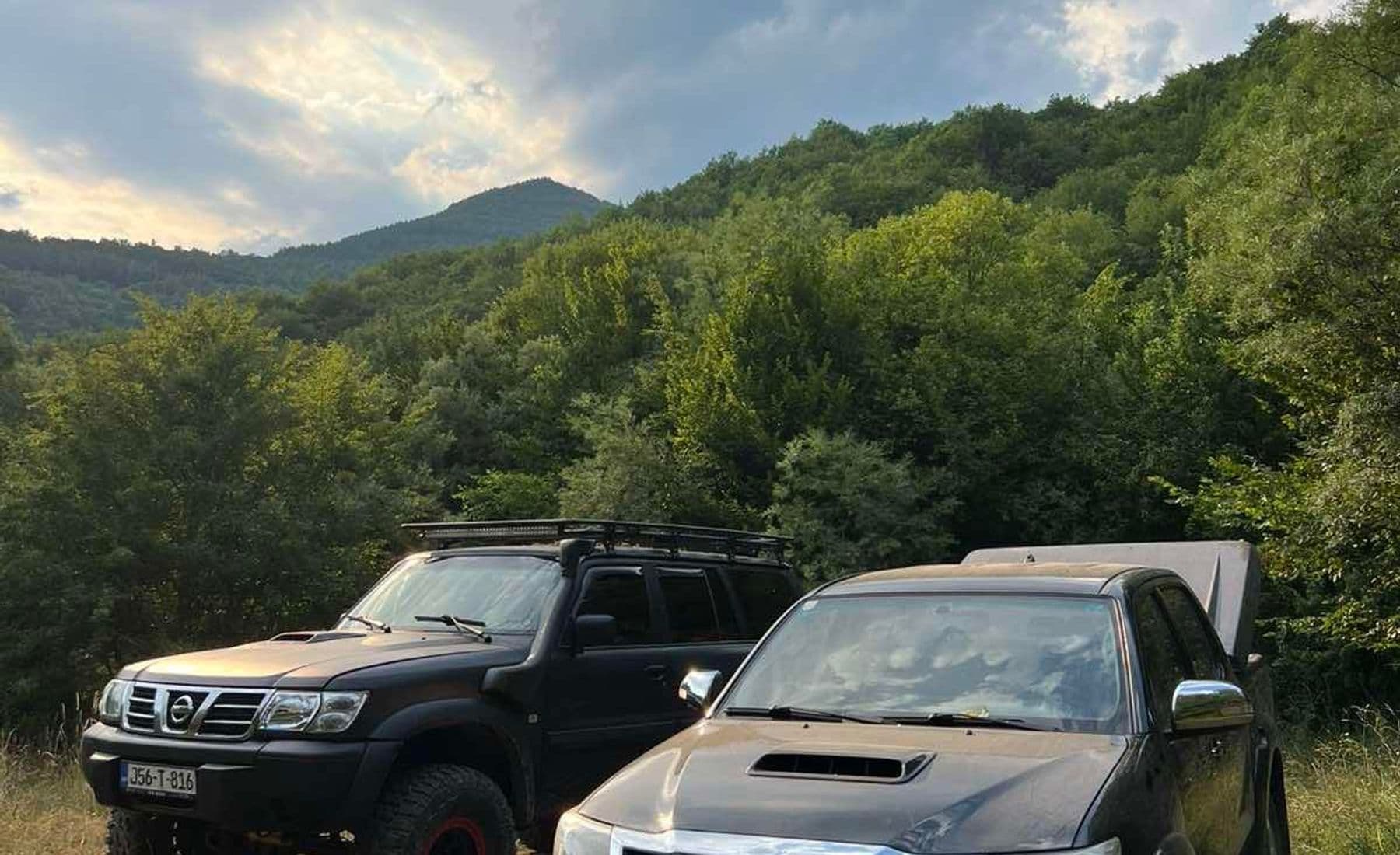 Dva terenca parkirana na rubu šume ispod pošumljenog grebena na bosanskoj off-road ruti
