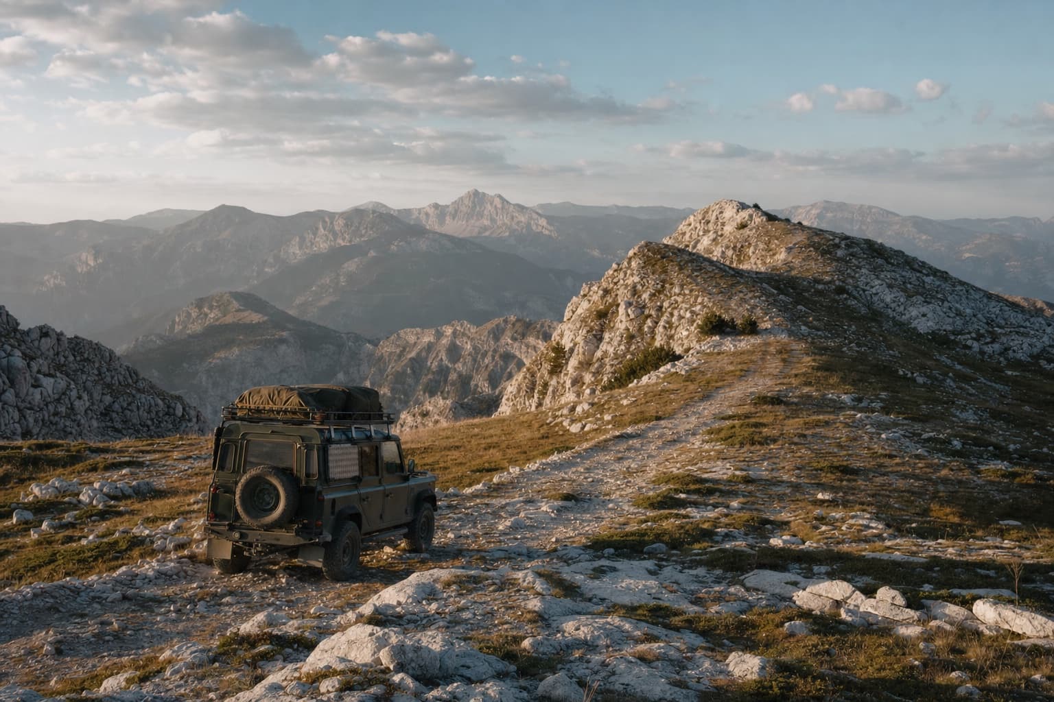 Expedition vehicle crossing a limestone ridge in the Dinaric Alps