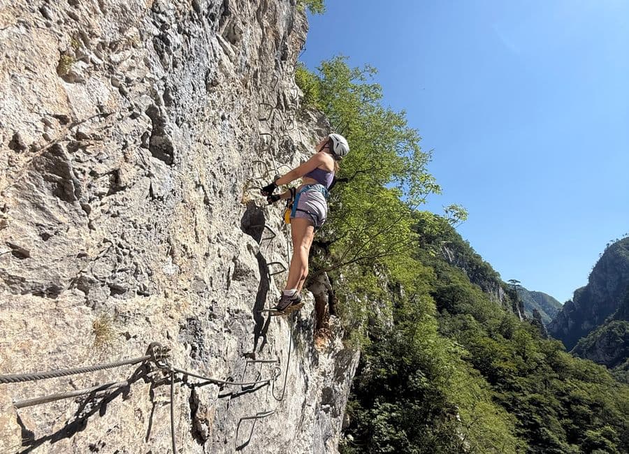 Climber on the rungs of the Via Ferrata Piva high above the green Piva canyon, Montenegro