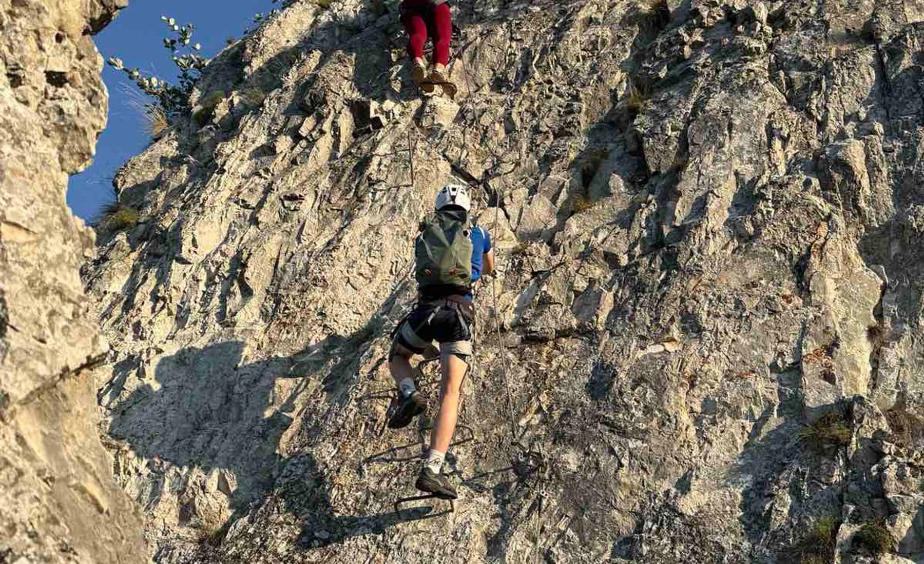 Two climbers on the metal rungs of the Bijele Stijene via ferrata on Trebević above Sarajevo