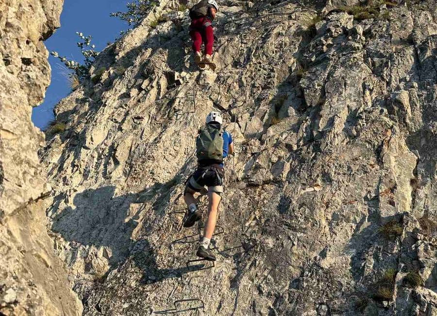 Two climbers on the metal rungs of the Bijele Stijene via ferrata on Trebević above Sarajevo